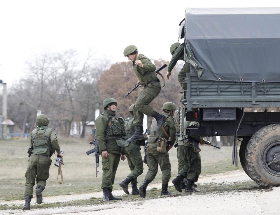 Russian servicemen disembark from a vehicle at the Belbek airport in the Crimea region