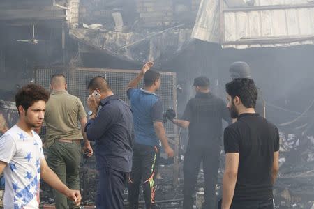 People gather at the site of a car bomb attack in Baghdad al-Jadida, Iraq April 25, 2016. REUTERS/Khalid al Mousily