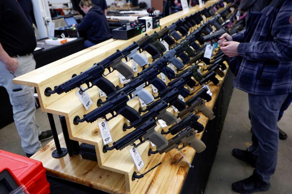 PHOTO: Customers shop for handguns at the Des Moines Fairgrounds Gun Show at the Iowa State Fairgrounds in Des Moines, Iowa, March 11, 2023. (Jonathan Ernst/Reuters)