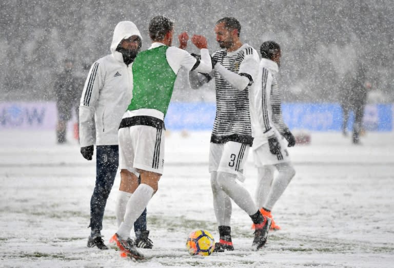 Big chill: Juventus' players warm up under heavy snowfall before the match against Atalanta in Turin was called off