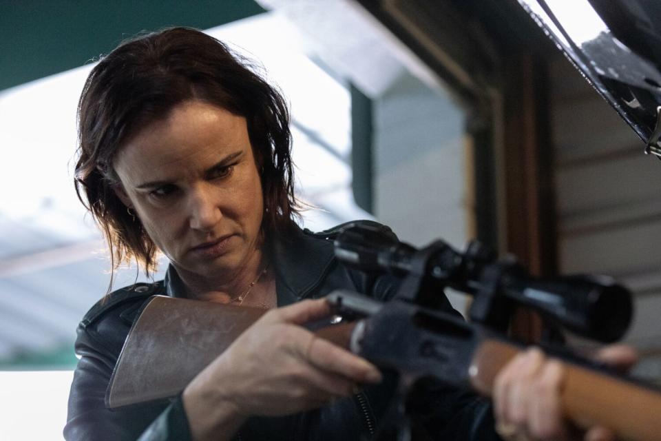 A woman (Juliette Lewis) holds a rifle with a sniper scope on "Yellowjackets."