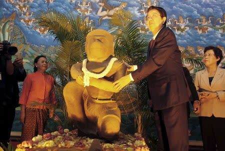 Cambodia's Deputy Prime Minister Sok An (2nd R) touches the kneeling monkey god statue of Hanuman at the Council of Ministers in Phnom Penh May 12, 2015. REUTERS/Samrang Pring