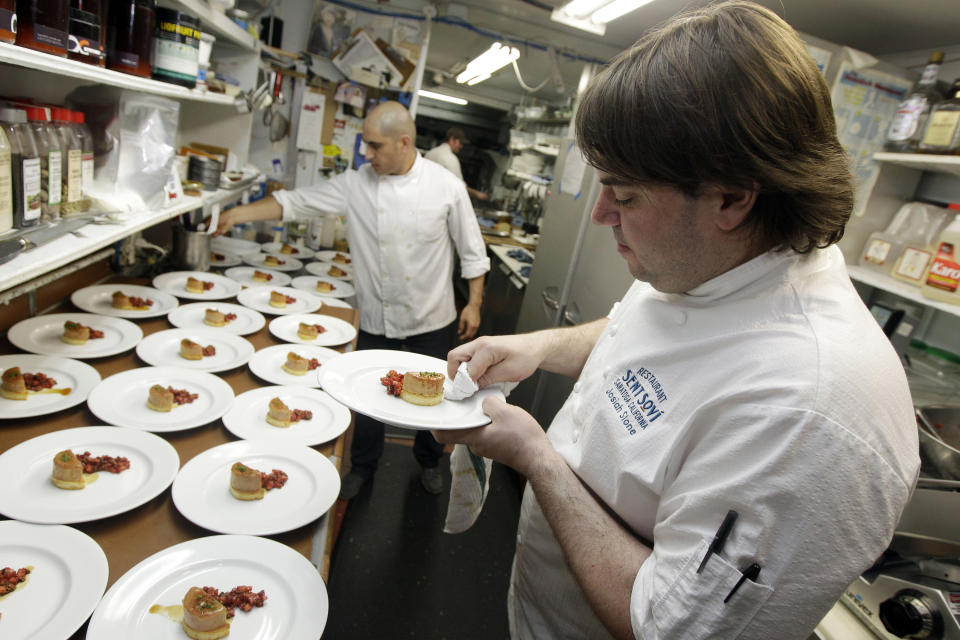 FILE - In this May 11, 2012, file photo, chef and owner Josiah Slone, right, prepares a foie gras dish at Sent Sovi restaurant in Saratoga, Calif. Foie gras is back on the menu in California after a judge ruled the rich dish can't be prevented from being brought in from out of state. California's ban on the delicacy, the fattened liver of a duck or goose, was challenged by out-of-state producers. An appeals court upheld the ban, but on Tuesday, July 14, 2020, a judge ruled for the plaintiffs, including farmers in Canada and New York. (AP Photo/Marcio Jose Sanchez, File)