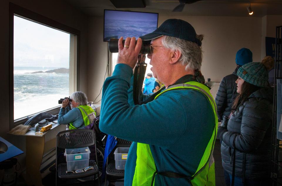 Volunteers Nancy Rasmussen, left, and husband Steve Rasmussen, center, look for whales from The Whale Watching Center in Depoe Bay on the first day of Whale Watch Week in 2022.