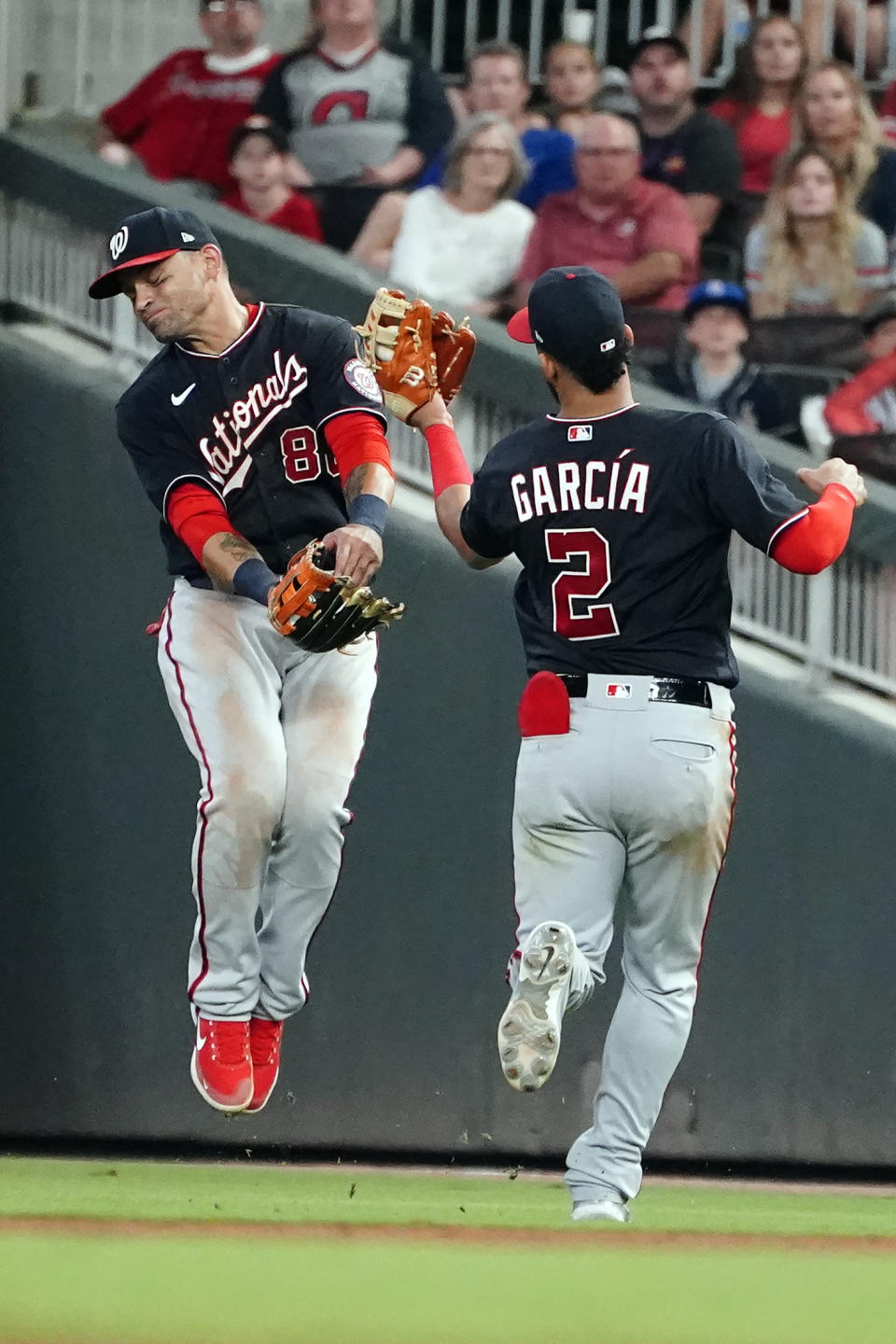 Washington Nationals shortstop Luis Garcia (2) avoids right fielder Gerardo Parra (88) as he catches a fly ball by Atlanta Braves' Austin Riley in the eighth inning of a baseball game Friday, Aug. 6, 2021, in Atlanta. (AP Photo/John Bazemore)