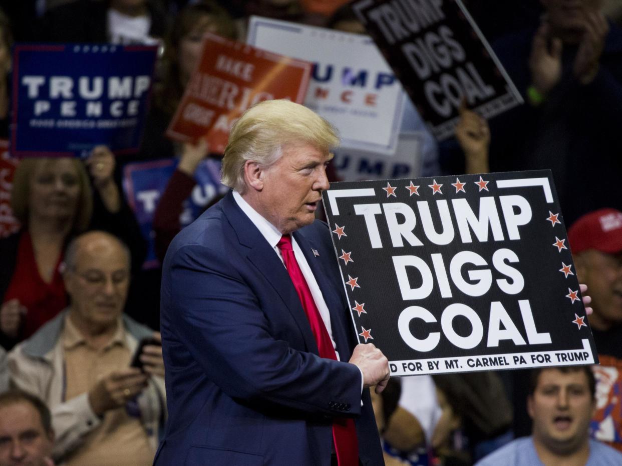 Republican presidential nominee Donald Trump holds a sign supporting coal during a rally at Mohegan Sun Arena in Wilkes-Barre, Pennsylvania: Getty