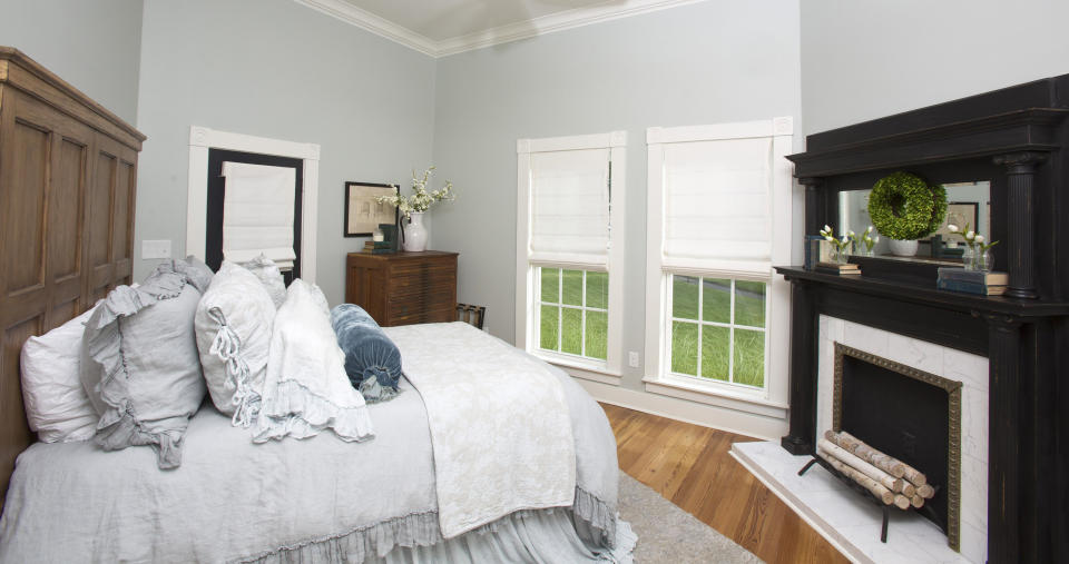 This downstairs bedroom features hardwood floors, cool gray wall paint and a restored fireplace. (Photo: Fort Worth Star-Telegram via Getty Images)