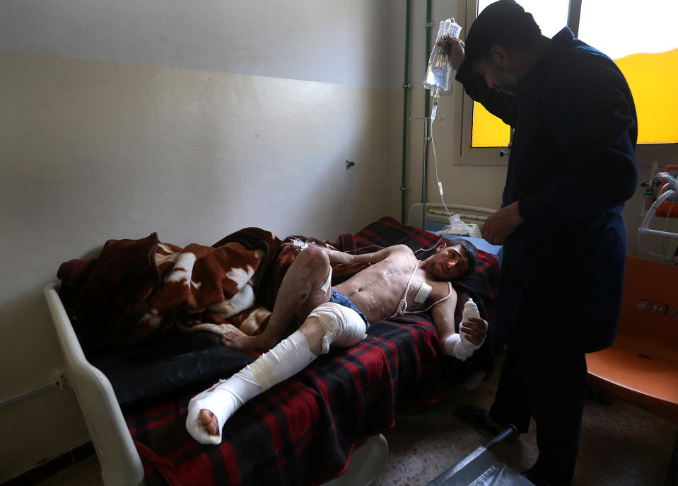 In this picture taken on Wednesday, March 5, 2014, a Lebanese nurse, right, helps Adul-Karim, 18, a Syrian rebel who was injured during a battle against government forces and Hezbollah fighters near Yabroud, the last rebel stronghold in Syria's mountainous Qalamoun region, lies on his bed at a makeshift hospital in the Lebanese-Syrian border town of Arsal, eastern Lebanon. Trucks of armed fighters rumble from this Lebanese Sunni town through the mountains to the front in Syria, where rebels are in a furious fight to keep a vital stronghold. At the same time, Lebanese Shiite fighters from a town not far away are also streaming in to join the battle _ but on the opposing side, backing Syrian government forces. The battle has effectively erased the border between the two countries and underlines how dangerously Lebanon is being sucked into its neighbor’s civil war. (AP Photo/Hussein Malla)