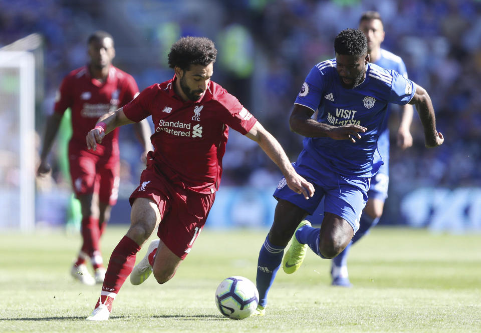 Liverpool's Mohamed Salah and Cardiff City's Bruno Ecuele Manga, right, battle for the ball during the English Premier League soccer match at The Cardiff City Stadium, Cardiff, Wales, Sunday April 21, 2019. (David Davies/PA via AP)