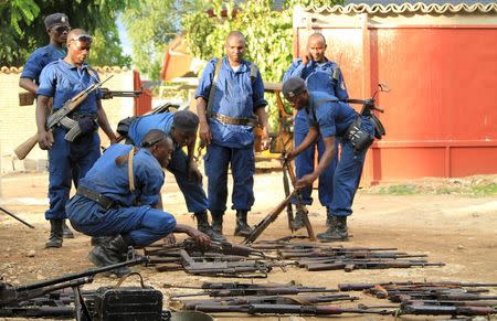 Burundian police officers collect a cache of weapons recovered from suspected fighters after clashes in the capital Bujumbura, Burundi December 12, 2015. REUTERS/Jean Pierre Aime Harerimana