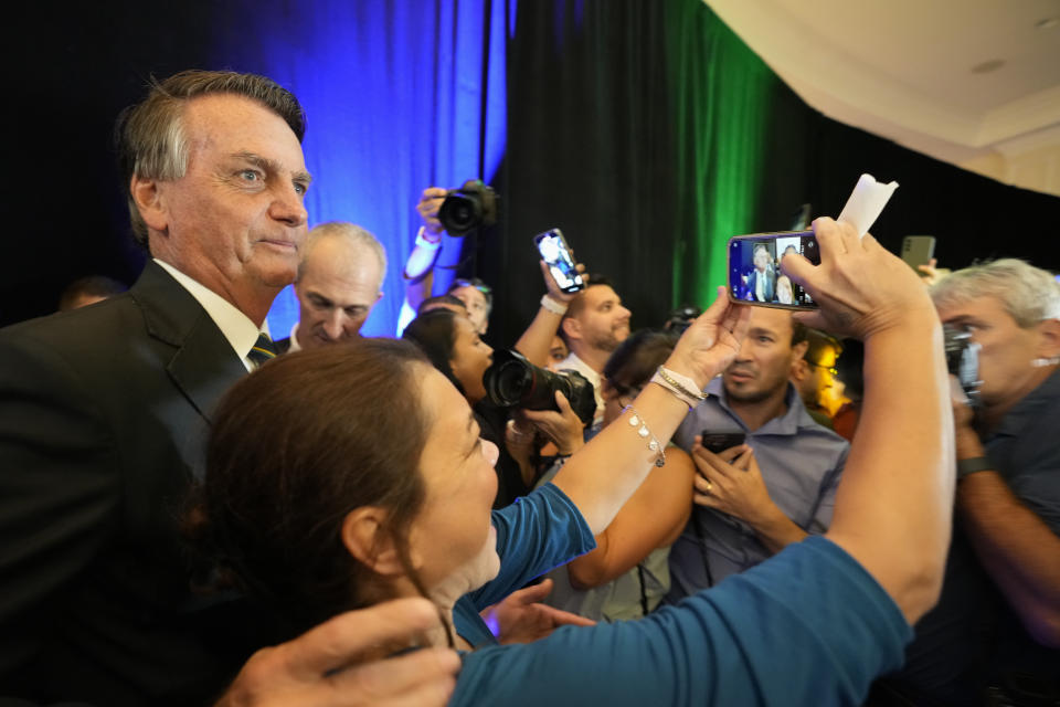 Brazil's right wing former President Jair Bolsonaro, left, takes a selfie with a supporter as he leaves after speaking at an event hosted by conservative group Turning Point USA, at Trump National Doral Miami, Friday, Feb. 3, 2023, in Doral, Fla. (AP Photo/Rebecca Blackwell)