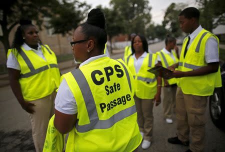 Safe Passage route workers gather outside Sherwood Elementary School before students begin to arrive in the Englewood neighborhood in Chicago, Illinois, United States, September 8, 2015. REUTERS/Jim Young