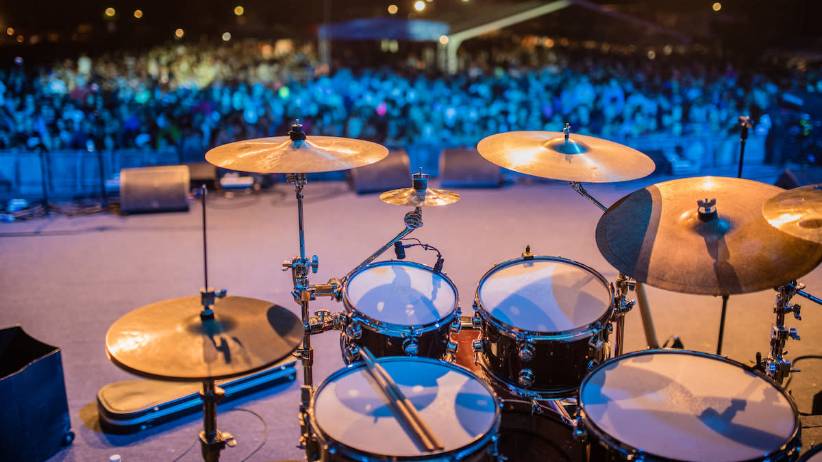  View from behind a drum kit on stage. 