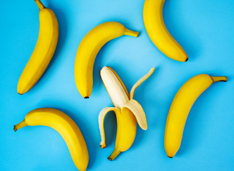 Ripe bananas on blue background, flat lay.