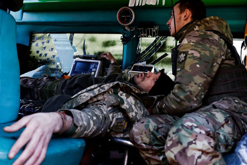 FILE PHOTO: Military medics treat wounded Ukrainian soldier at eastern front line