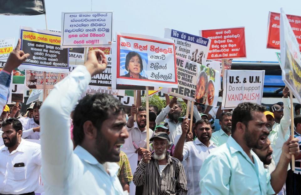 FILE - In this March 26, 2014 file photo Sri Lankan government supporters shout slogans against the U.S. and U.N. during a demonstration in Colombo, Sri Lanka. The U.N.'s top human rights body has approved Thursday, March 27, 2014, an international criminal investigation into alleged abuses in Sri Lanka's civil war, which ended in 2009. Members of the 47-nation U.N. Human Rights Council have agreed to set up the yearlong investigation, estimated to cost US dollar 1.46 million, based on the recommendation of U.N. High Commissioner for Human Rights Navi Pillay. Placard carrying a portrait of Pillay reads "Navi Pillay hangs on to tiger tail." (AP Photo/Eranga Jayawardena, File)