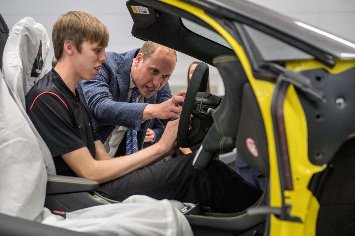 Britain's Prince William, Duke of Cambridge (R) helps fit an airbag to a McLaren car with apprentice of the year nominee, Alex Machin on the factory floor in Woking, west of London on September 12, 2017, during his visit to McLaren Automotive Production Centre. During the visit the Duke toured the technology centre and production centre where he got to see McLaren cars throughout the years as well as walk the factory floor to view the building of their commercial cars and speak to employees. / AFP PHOTO / POOL / CHRIS J RATCLIFFE        (Photo credit should read CHRIS J RATCLIFFE/AFP via Getty Images)