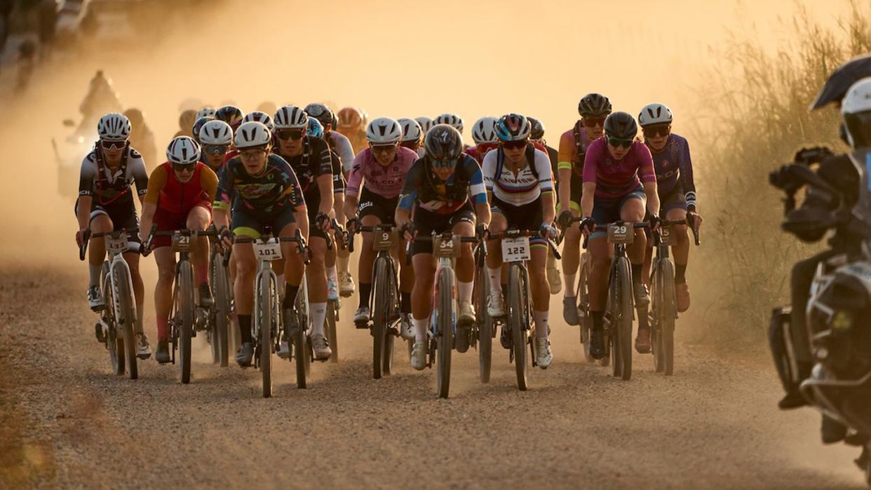 a group of cyclists riding on gravel