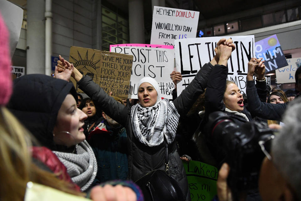 Demonstrators protest outside at an airport terminal. (Patrick Gorski / Icon Sportswire via AP file)