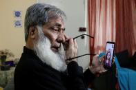 Ali Hasan Baqai, speaks on a video call, with his Indian citizen sister Shehla, at his home in Karachi