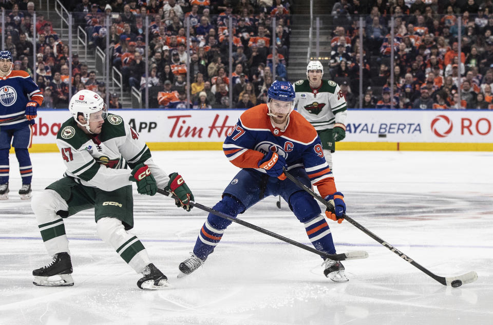 Minnesota Wild's Declan Chisholm (47) and Edmonton Oilers' Connor McDavid (97) vie for the puck during the second period of an NHL hockey game Friday, Feb. 23, 2024, in Edmonton, Alberta. (Jason Franson/The Canadian Press via AP)