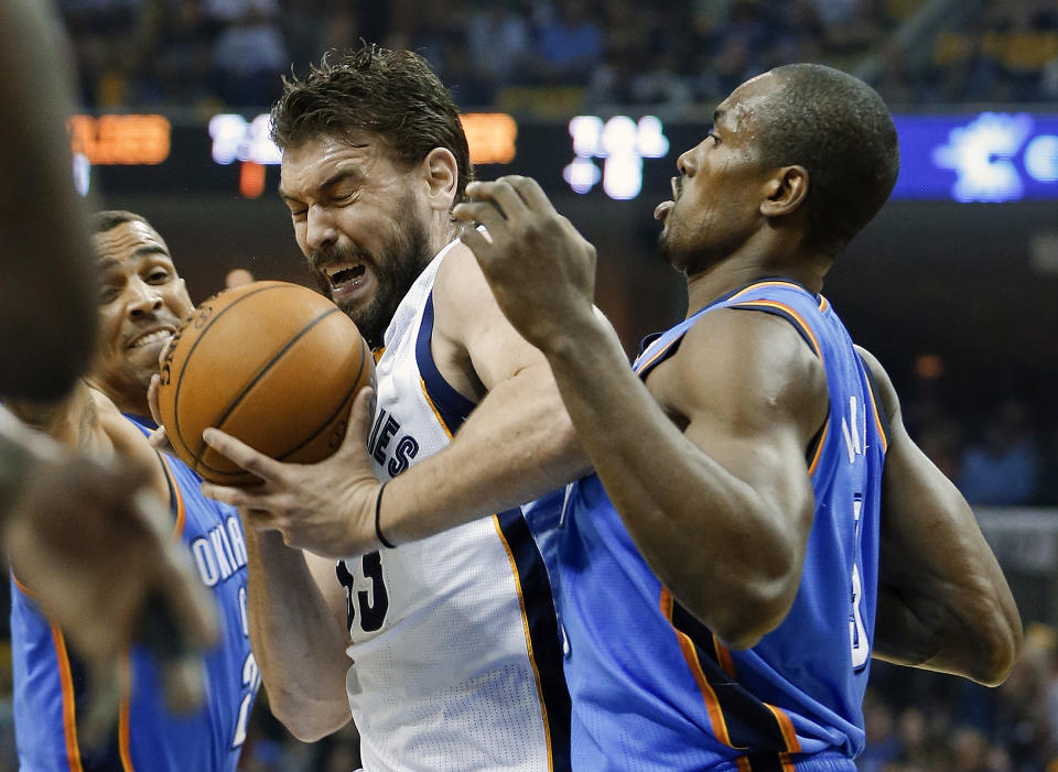 Memphis Grizzlies center Marc Gasol is squeezed between Oklahoma City Thunder defenders Thabo Sefolosha, left, and Serge Ibaka during the first half of Game 4 of an opening-round NBA basketball playoff series Saturday, April 26, 2014, in Memphis, Tenn. (AP Photo/Mark Humphrey)