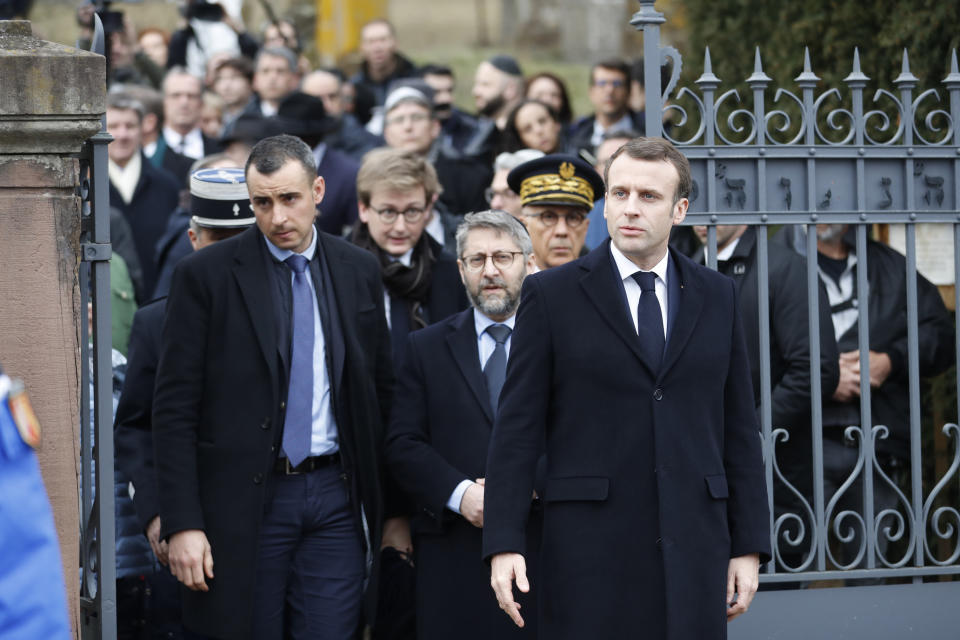 French President Emmanuel Macron, right, with France's Chief Rabbi Haim Korsia, center, leave the Jewish cemetery where tombs were tagged with swastikas in Quatzenheim, eastern France, Tuesday, Feb.19, 2019. Marches and gatherings against anti-Semitism are taking place across France following a series of anti-Semitic acts that shocked the country. (AP Photo/Jean-Francois Badias)