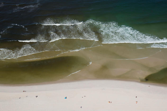 <p>In this July 5, 2016 photo, aerial view shows polluted water, left, flowing from the Barra channel to the Barra beach in Rio de Janeiro, Brazil. Tourists are unlikely to realize the dangers lurking in the waters and the sands. Signs alerting beachgoers whether waters are considered fit for bathing used to dot showcase beaches, but they’re no longer there. Now, a brief item on the weather page of the local paper lists which beaches the state environmental agency has deemed safe for swimming. (AP Photo/Felipe Dana)