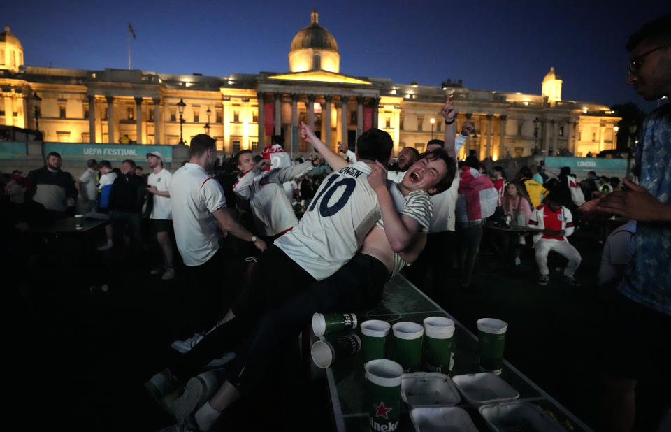 England fans celebrate in the fan zone of Trafalgar Square after England scored during the Euro 2020 soccer championship semifinal match between England and Denmark at Wembley Stadium in London, Wednesday, July 7, 2021, (AP Photo/Matt Dunham)