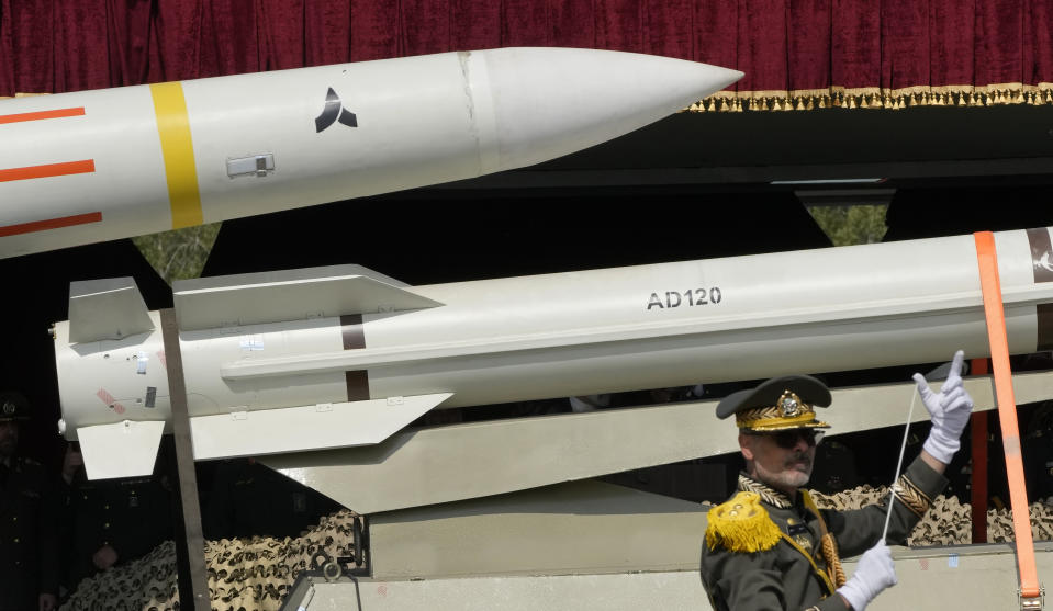 Missiles are carried on a truck as an Iranian army band leader conducts the music band during Army Day parade at a military base in northern Tehran, Iran, Wednesday, April 17, 2024. In the parade, President Ebrahim Raisi warned that the "tiniest invasion" by Israel would bring a "massive and harsh" response, as the region braces for potential Israeli retaliation after Iran's attack over the weekend. (AP Photo/Vahid Salemi)