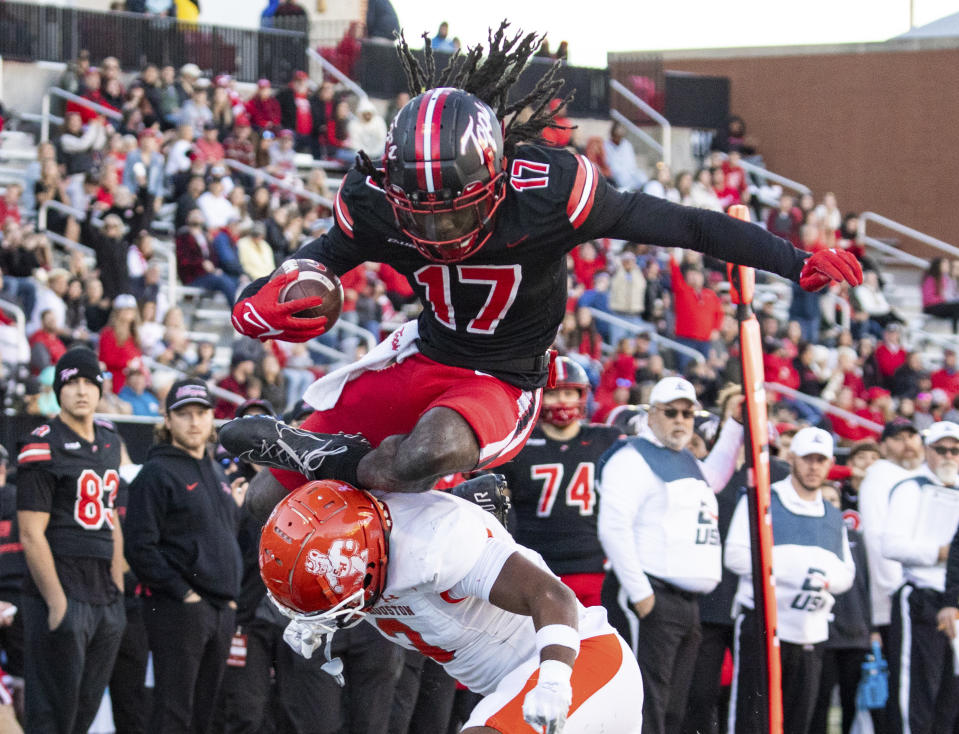 Western Kentucky wide receiver Dalvin Smith (17) leaps over Sam Houston defensive back Caleb Weaver (3) during an NCAA college football game Saturday, Nov. 18, 2023, in Bowling Green, Ky. (Grace Ramey/Daily News via AP)