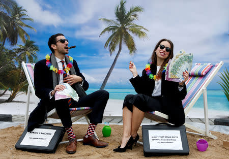 FILE PHOTO: Activists stage a protest on a mock tropical island beach representing a tax haven outside a meeting of European Union finance ministers in Brussels, Belgium, December 5, 2017. REUTERS/Francois Lenoir/File Photo