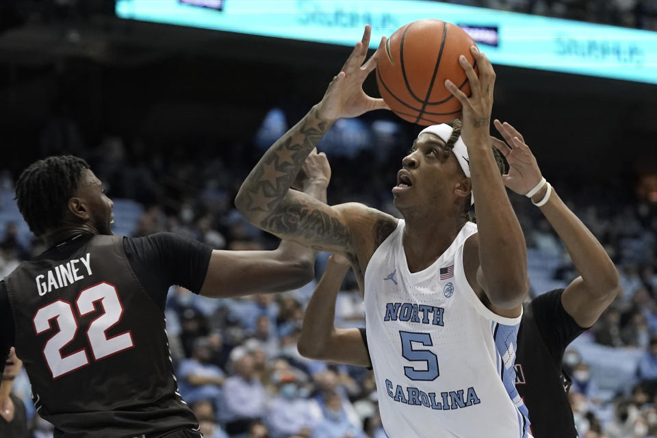North Carolina forward Armando Bacot (5) drives to the basket while Brown forward Jaylan Gainey (22) defends during the first half of an NCAA college basketball game in Chapel Hill, N.C., Friday, Nov. 12, 2021. (AP Photo/Gerry Broome)