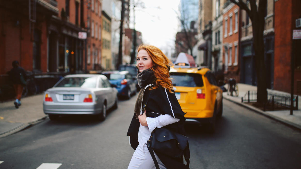 Vintage toned portrait of a young redhead New Yorker woman, walking on a nice and sunny spring day through the streets of West Village, in Lower Manhattan area.