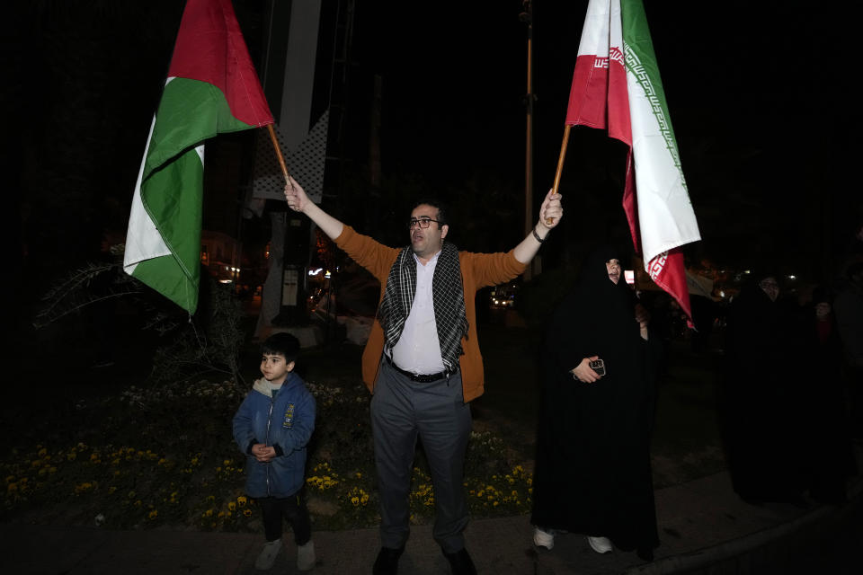 A demonstrator waves Iranian and Palestinian flags during an anti-Israeli gathering at the Felestin (Palestine) Square in Tehran, Iran, early Sunday, April 14, 2024. Iran launched its first direct military attack against Israel Saturday. The Israeli military says Iran fired more than 100 bomb-carrying drones toward Israel. Hours later, Iran announced it had also launched much more destructive ballistic missiles. (AP Photo/Vahid Salemi)