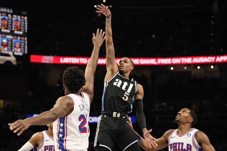 Atlanta Hawks guard Dejounte Murray (5) shoots against Philadelphia 76ers center Joel Embiid (21) during the first half of an In-Season Tournament NBA basketball game, Friday, Nov. 17, 2023, in Atlanta. (AP Photo/Mike Stewart)