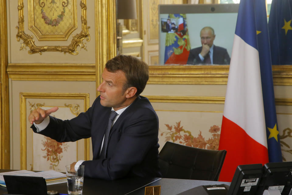 French President Emmanuel Macron talks to Russian President Vladimir Putin during a video conference Friday, June 26, 2020 at the Elysee Palace in Paris. Russian President Vladimir Putin holds video talks with French President Emmanuel Macron about the virus, Libya, Syria and relations with the U.S. under Donald Trump. (AP Photo/Michel Euler, Pool)