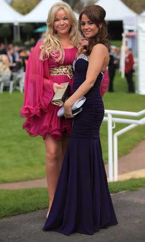 <b>Grand National Glamour</b><br><br> Two ladies take Liverpool Day fashion at Aintree seriously with a floor-length gown and cascading blonde curls.