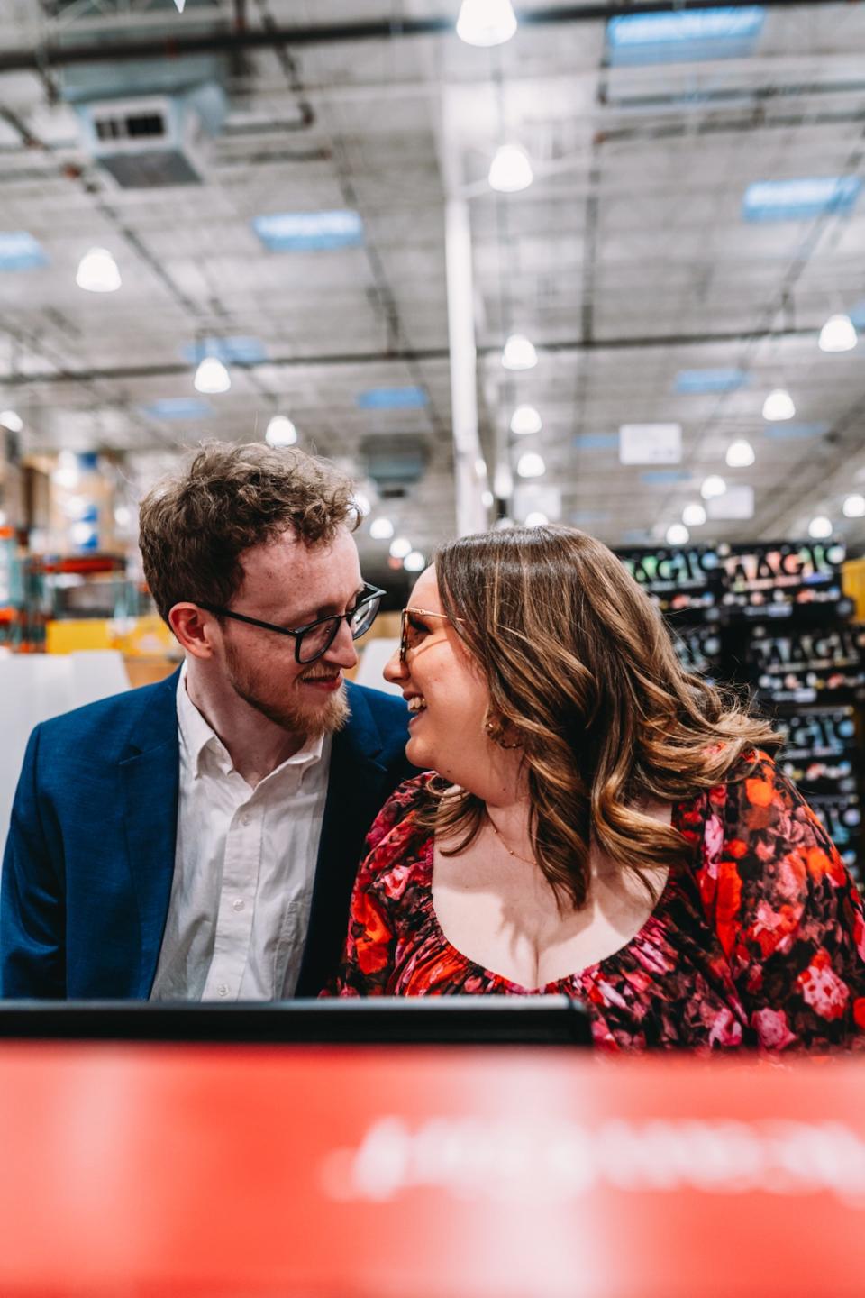 A couple smile and look at each other as they sit in front of a keyboard.