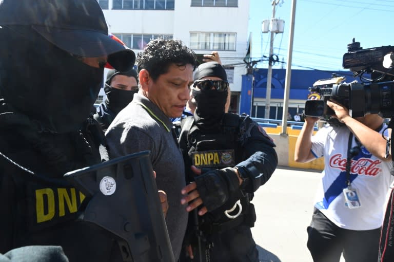(ARCHIVOS) Miembros de la Dirección Antidrogas de la Policía trasladan a los tribunales de justicia al exfutbolista hondureño Oscar “Pescado” Bonilla, acusado de narcotráfico en Tegucigalpa, el 28 de enero de 2024. Un tribunal hondureño condenó al exfutbolista Oscar “Pescado” " Bonilla a once años y tres meses de prisión el 31 de julio de 2024, luego de admitir el "error" de involucrarse en el narcotráfico. (Orlando SIERRA)