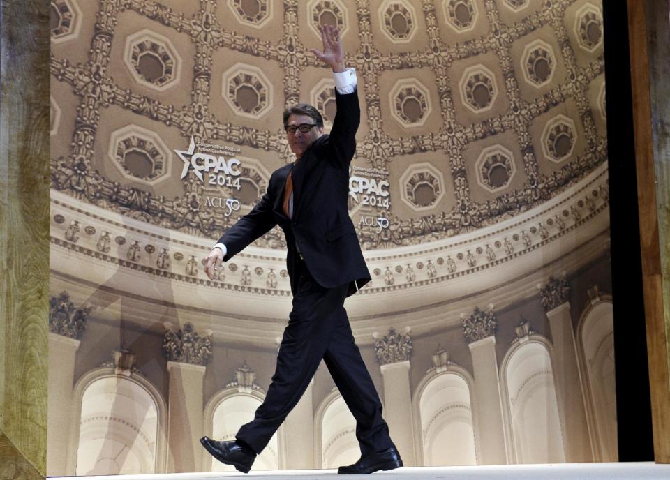 FILE - In this March 7, 2014 file photo Texas Gov. Rick Perry waves as he walks off of the stage after speaking at the Conservative Political Action Committee annual conference in National Harbor, Md. Perry has spent a record 14 years in office, but with eight months left he is now the focus of a grand jury investigation over a veto last summer. (AP Photo/Susan Walsh, File)