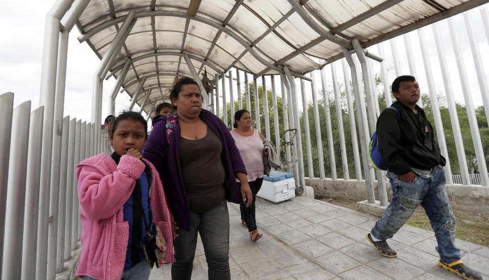 FILE- In this Saturday, Nov. 3, 2018, file photo immigrants seeking asylum in the United States walk off of the the International Bridge in Reynosa, Mexico. Asylum seekers already camping at border crossings worry that how the Trump administration responds to the caravan of some 4,000 Central American migrants and three much smaller ones hundreds of miles behind it could leave them shut out. (AP Photo/Eric Gay, File)