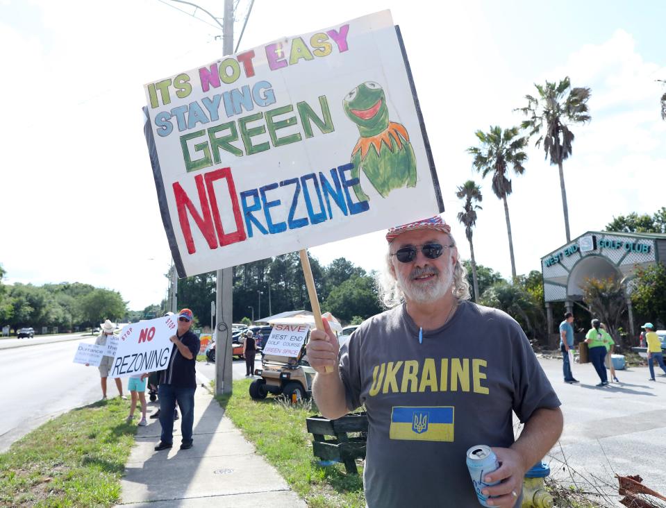 William Hatfield, who lives in the West End area of Jonesville, holds his sign as he and a group of about twenty protesters make their voices heard against the rezoning of the old West End Golf Course, west of Gainesville, April 18, 2022. The old West End Golf Course has been closed for several years. On Wednesday a planning board will decide if the old West End Golf Course will be rezoned to allow for a multi-use development. Some locals want the are to become a park and green space.