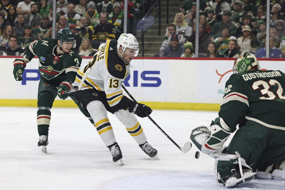Boston Bruins center Charlie Coyle (13) tries to score a goal against Minnesota Wild goaltender Filip Gustavsson (32) during the second period of an NHL hockey game Sunday, March 18, 2023, in St. Paul, Minn. (AP Photo/Stacy Bengs)