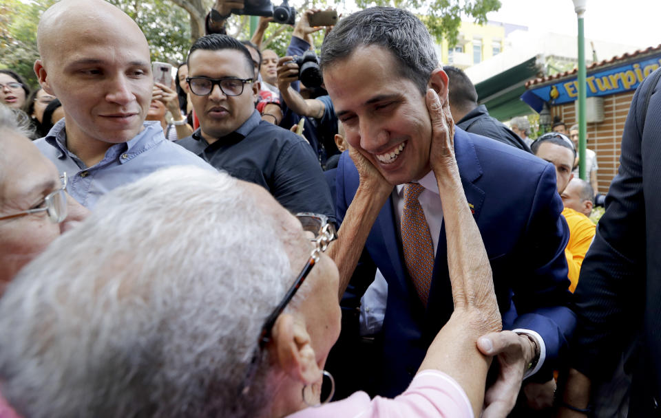 Juan Guaido, Venezuelan opposition leader and self-proclaimed interim president, is greeted by a supporter as he leaves a meeting at a university in Caracas, Venezuela, Monday, April 1, 2019. He’s backed by more than 50 nations, which consider Nicolas Maduro’s presidency illegitimate following what they call sham elections last year. “We must unite now more than ever,” said Guaido, speaking at the university. "We must mount the biggest demonstration so far to reject what’s happening." (AP Photo/Natacha Pisarenko)