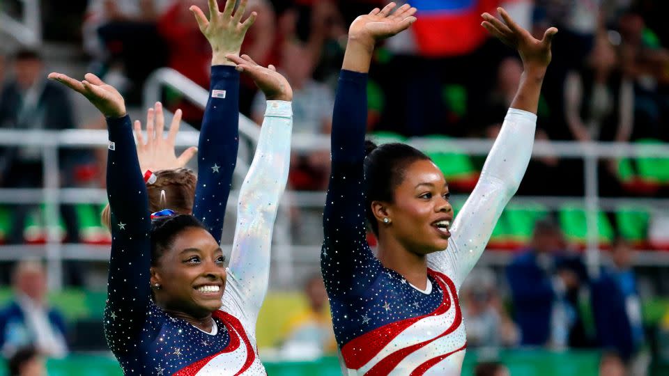 US gymnast Simone Biles and US gymnast Gabrielle Douglas (R) celebrate after the women's team final Artistic Gymnastics at the Olympic Arena during the Rio 2016 Olympic Games. - Thomas Coex/AFP/Getty Images