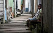 A boy sits on a bench in Ciudad 2000, a shantytown that is home to people displaced by turf wars between criminal gangs in Tumaco described as one of the epicenters of Colombian drug violence