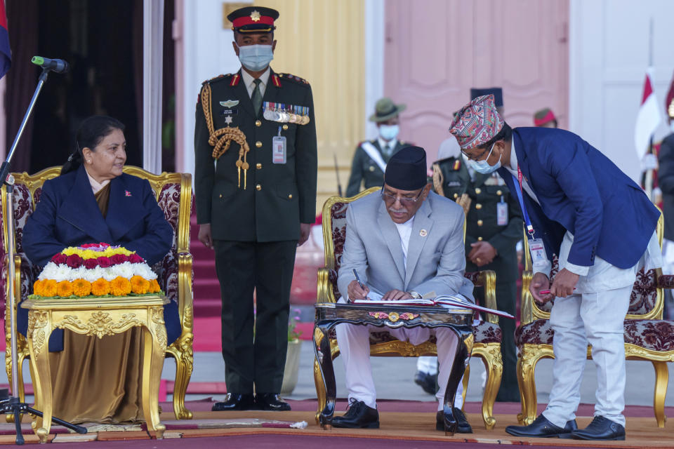 Nepal’s newly appointed prime minister Pushpa Kamal Dahal, right, sign documents after he was sworn in by President Bidhya Devi Bhandari, left, at the President House in in Kathmandu, Nepal, Monday, Dec. 26, 2022. Dahal has appointed three deputies and four other ministers in the Cabinet that is expected to be expanded in the next few days to accommodate more members from the seven parties in the new coalition government. (AP Photo/Niranjan Shrestha)