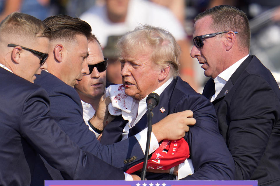 El expresidente y virtual candidato presidencial republicano Donald Trump recibe ayuda para bajar del estrado en un mitin de campaña en Butler, Pensilvania, el sábado 13 de julio de 2024. (AP Foto/Gene J. Puskar)