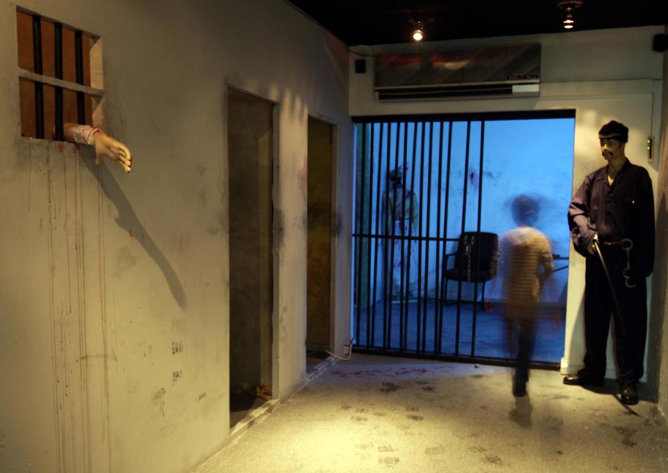 In this picture taken Monday, Oct. 28, 2013, an unidentified Bahraini boy walks through an interactive museum-style exhibition opened by an opposition group in Manama, Bahrain. Riot police in Bahrain stormed the exhibition on Wednesday, Oct. 30, that is dedicated to the Arab Spring-inspired uprising in the violence-wracked Gulf nation where crackdowns have strained ties between the ruling dynasty and their allies in Washington and elsewhere in the West. (AP Photo/Hasan Jamali)